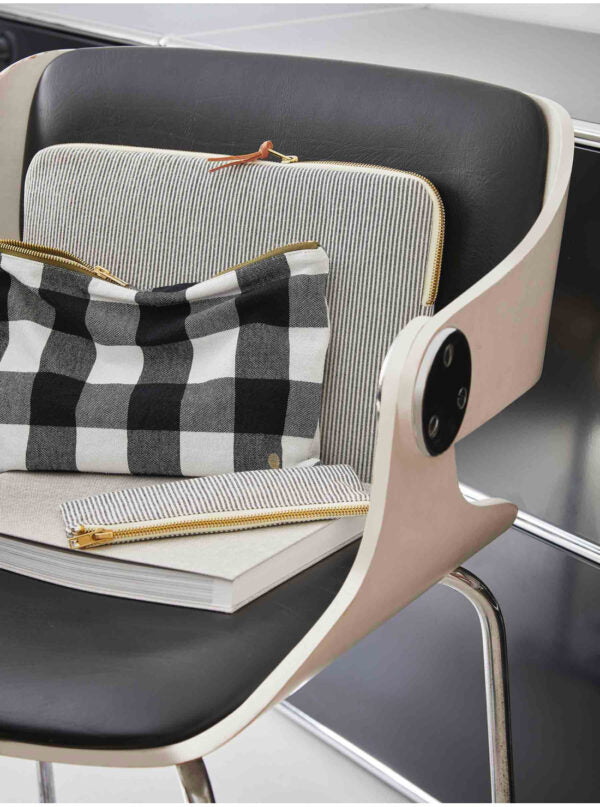 gestreifte laptophuelle aus baumwolle in schwarz-weiss auf stuhl arrangiert