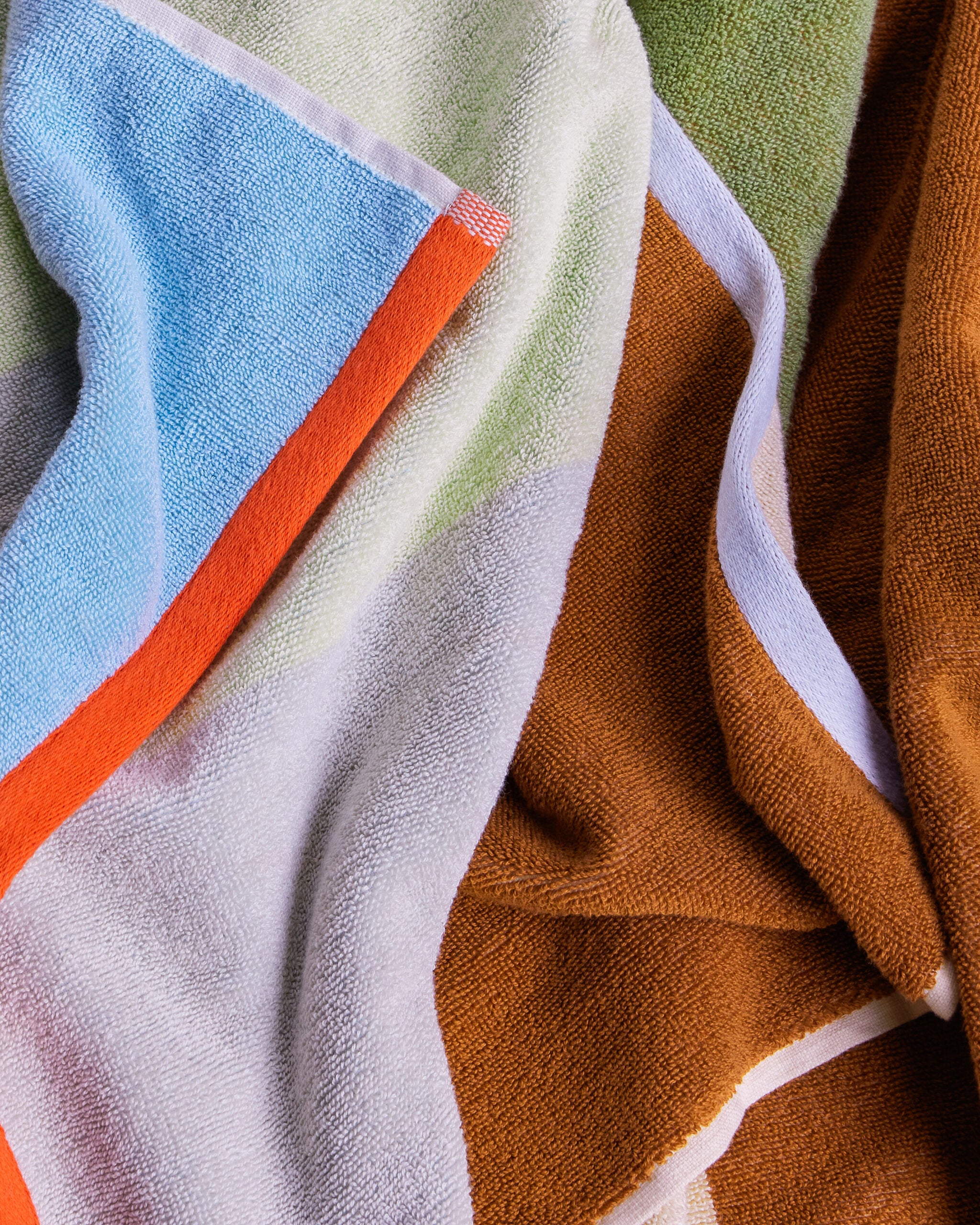 detailaufnahme bunt gemusterter baumwoll handtücher in blau orange braun und mint