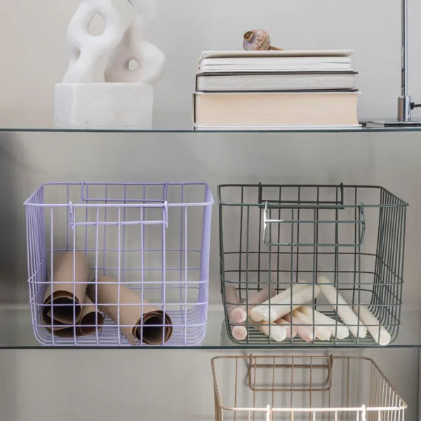 drahkorb in lila und gruen auf glastablar mit gerolltem papier und mit kerzen