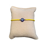Gelbes Glasperlenarmband auf einem Stoffkissen