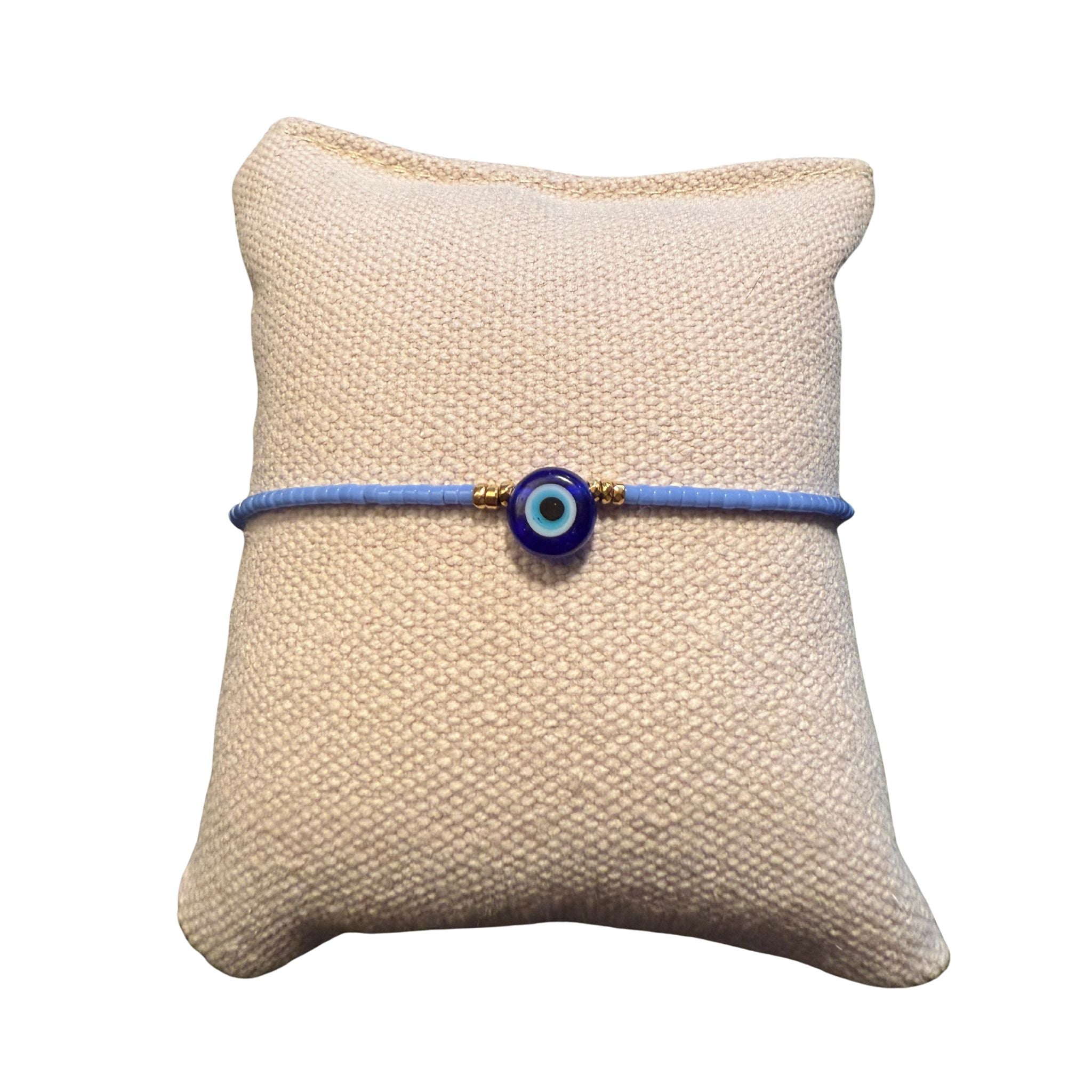 Hellblaues Glasperlenarmband auf einem Stoffkissen