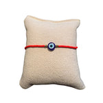 Rotes Glasperlenarmband auf einem Stoffkissen