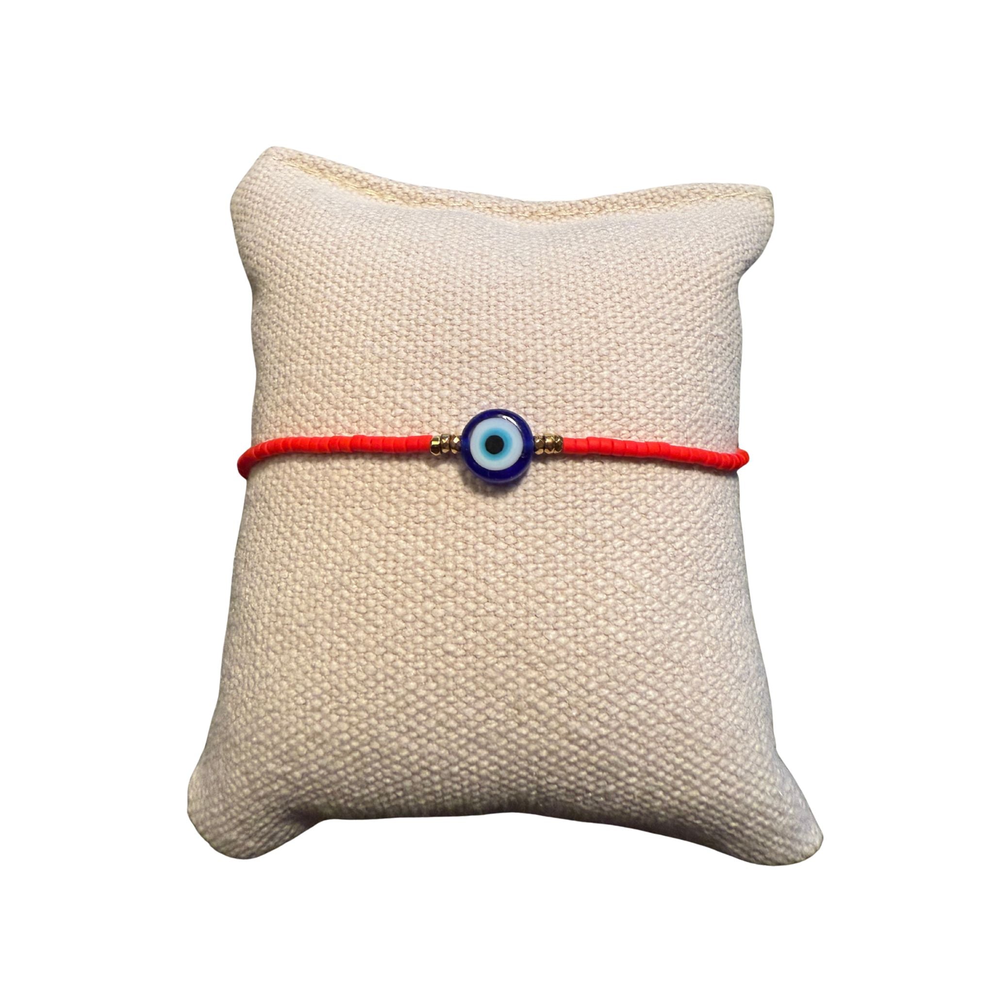 Rotes Glasperlenarmband auf einem Stoffkissen