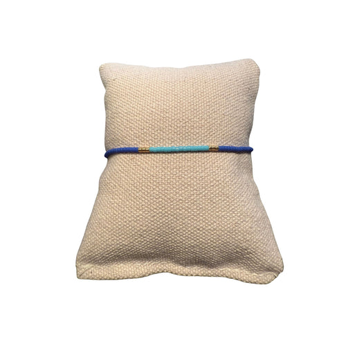 Zweifarbiges Perlenarmband in blau und hellblau getrennt duch jeweils drei goldene Perlen.