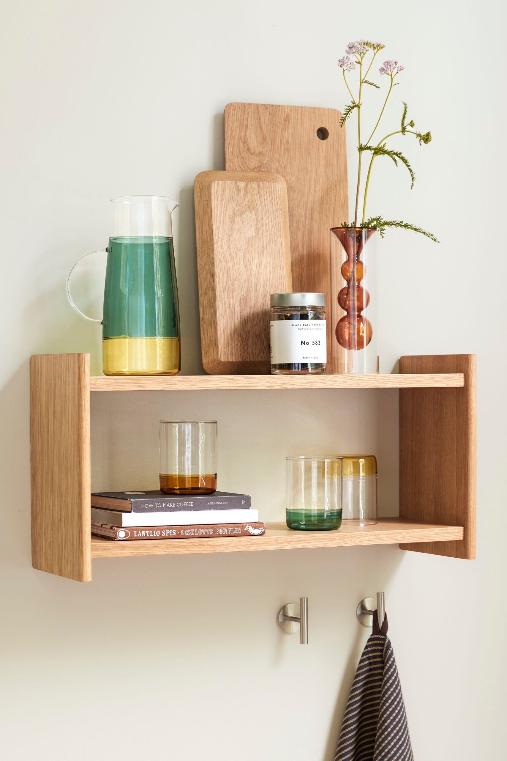 karaffe aus glas mit grünem und gelbem farbverlauf auf holzregal in der küche