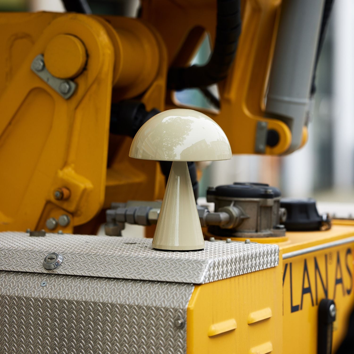 Sandfarbene tragbare Lampe auf gelber Baumaschine dekoriert