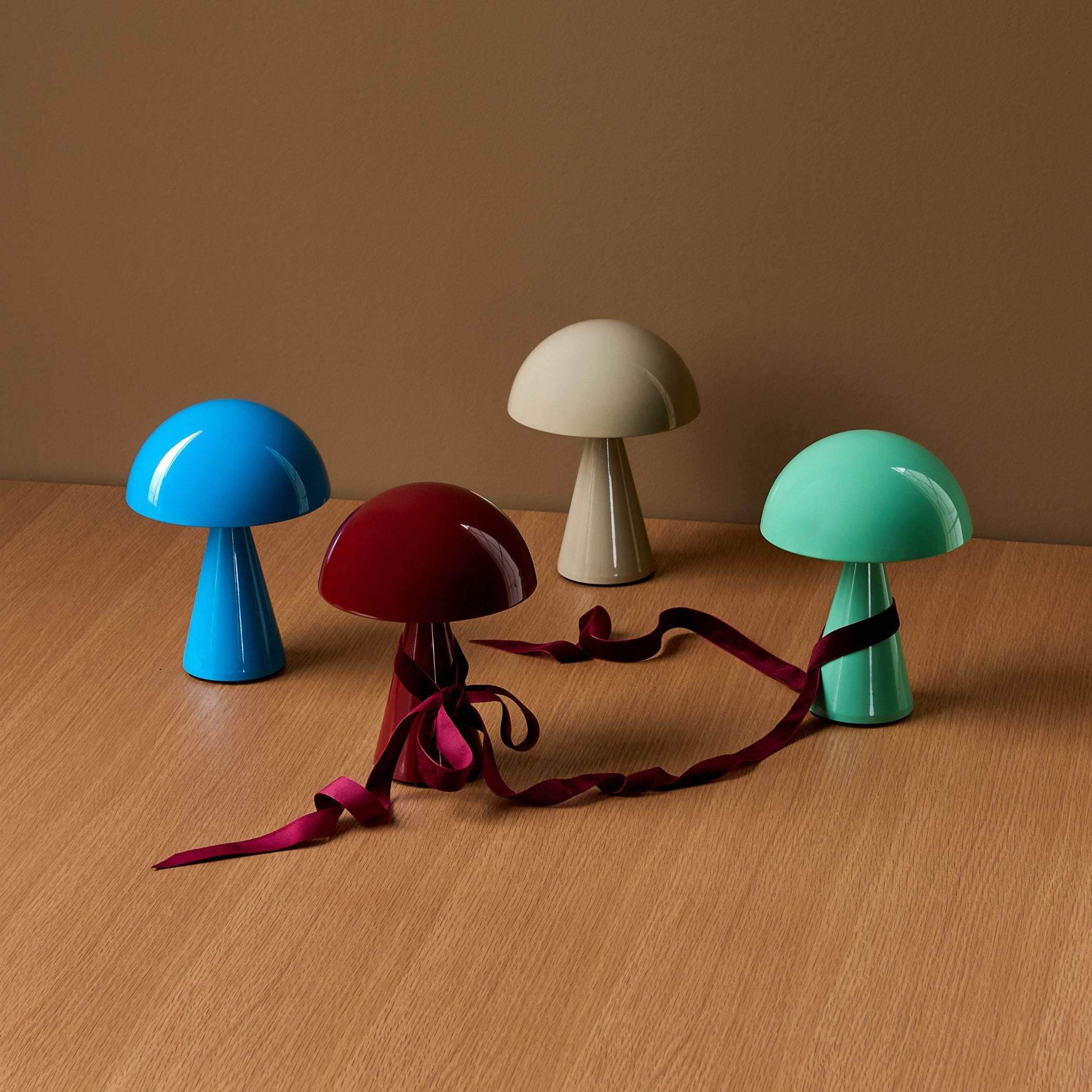 Vier bunte Mush Lampen von Huebsch auf einem Tisch.