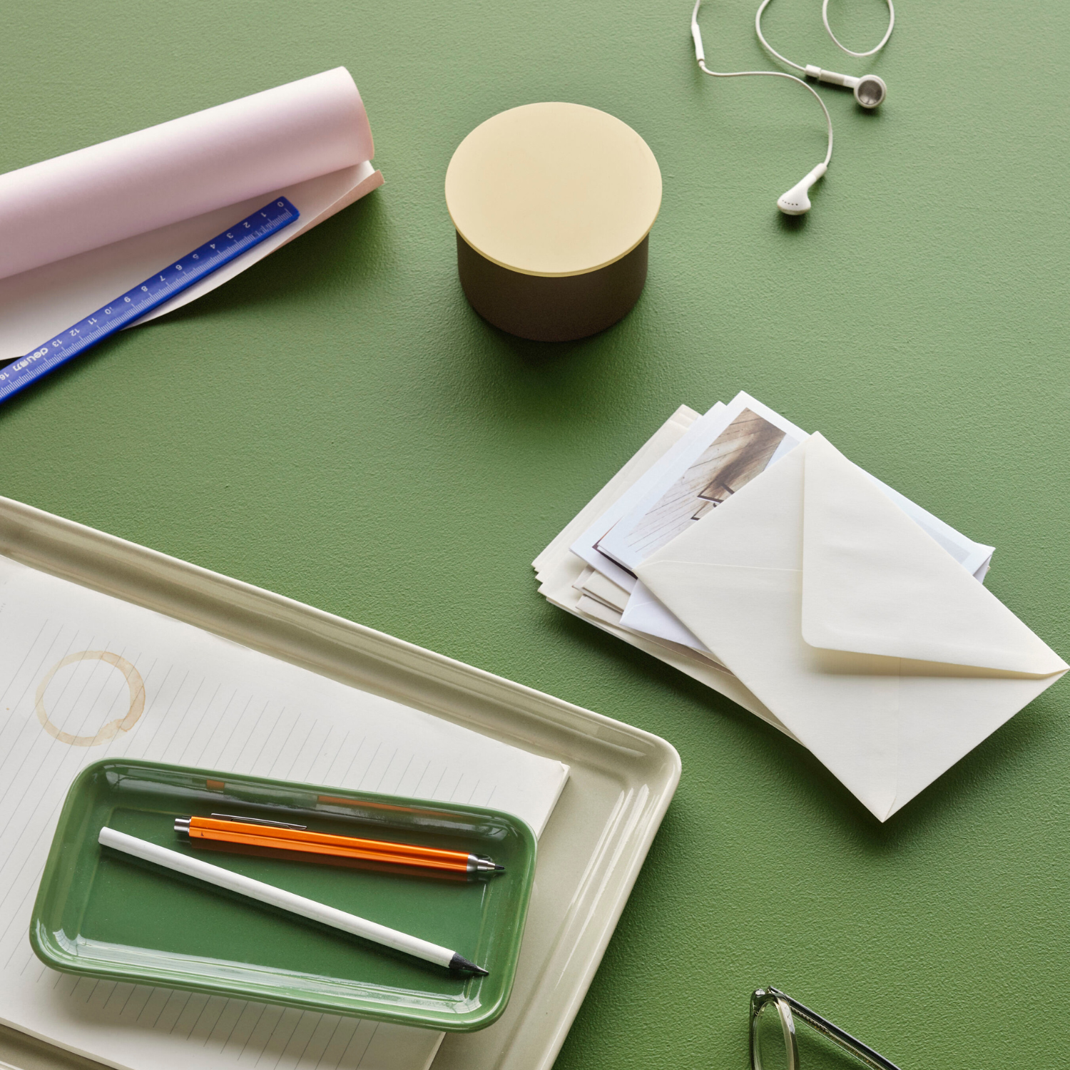 Kleine braune Metaldose auf gruenem Tisch mit Karten und Briefumschlaegen