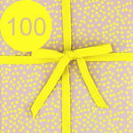 Geschenkpapier mit einer gelben Schleife und der Zahl 100.