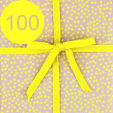 Geschenkpapier mit einer gelben Schleife und der Zahl 100.