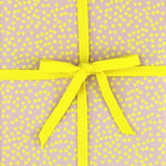 Geschenkpapier mit einer gelben Schleife