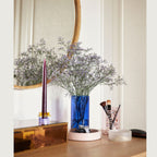 Blaues Pop Glas von Huesch als Vase auf einer Kommode.