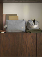 zwei gestreifte stofftaschen aus bio-baumwolle in würfelform auf einem holzregal, eine geöffnet