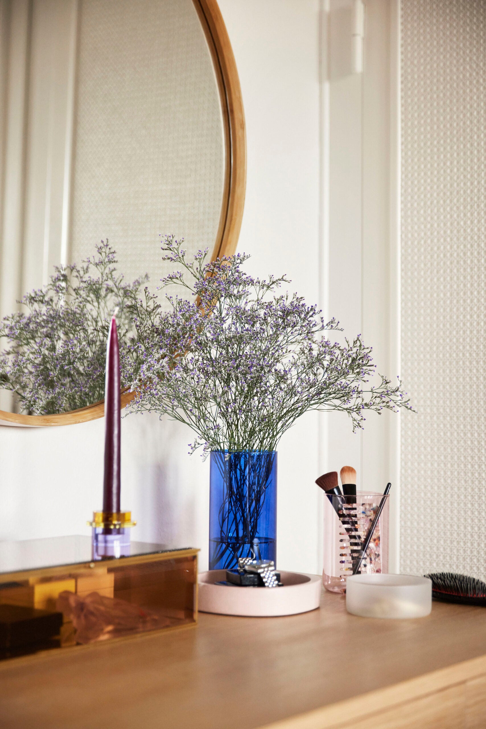 baue glasvase mit zweigen auf einer kommode dekoriert