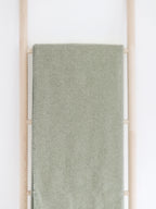 riema germany kuscheldecke finn grün aus bio baumwolle mit fischgrätmuster auf holzleiter