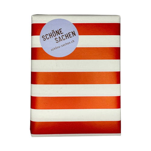 Beispiel einer Geschenkverpackung mit rot-weiss-gestreiftem Papier und einem Schöne Sachen Aufkleber.