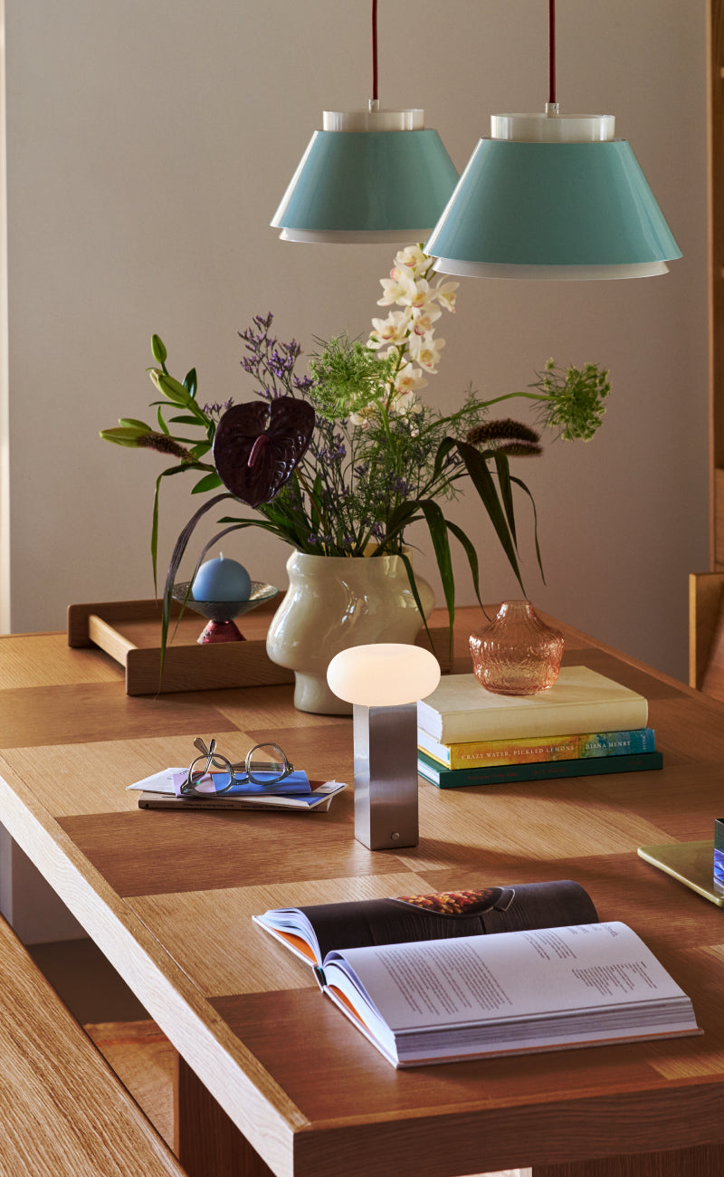 Dekorierter Wohnzimmertisch mit Vase und offenem Buch.