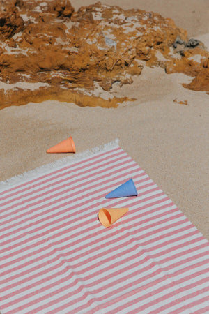 Gestreiftes Torres Novas Barra Strandtuch in Rosa und Weiß am Sandstrand